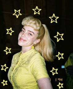 a young woman with blonde hair and stars in the background