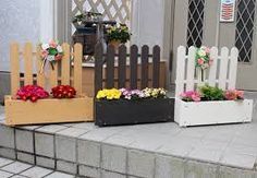 three wooden boxes with flowers in them sitting on the side of a house door step