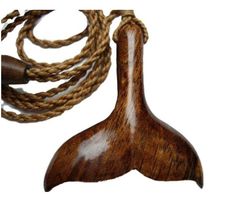 a piece of wood that is attached to a rope on a white background with the image of a whale tail