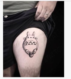 a person with a tattoo on their leg that has a totoro drawn on it