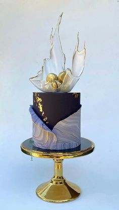 a three tiered cake with gold decorations on top