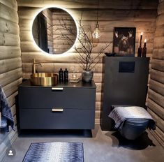 a bathroom with wooden walls and a round mirror on the wall above the vanity area