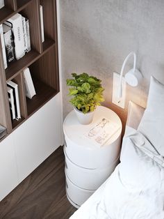 a plant is sitting on top of a round table in the corner of a bedroom