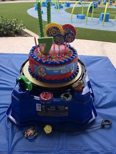 a mickey mouse birthday cake on top of a blue table cloth at a children's park