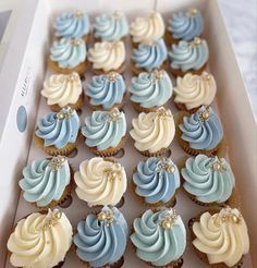 a box filled with blue and white cupcakes