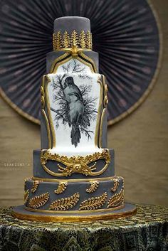 a three tiered cake decorated with an image of a bird on the front and sides