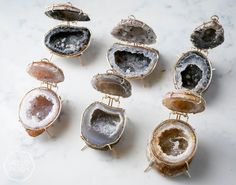 several different types of agate beads on a white surface with gold pins in them