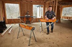 a man standing in an unfinished room with tools