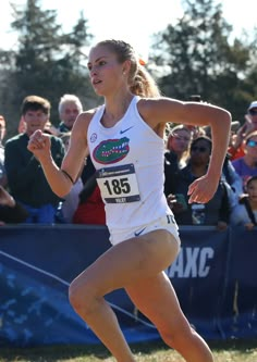 a woman running in a race with people watching