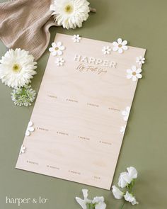 a wooden calendar with flowers on it next to a cloth and some other things that are laying around