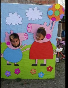 two children are standing in front of a peppa pig cardboard cutout on the grass