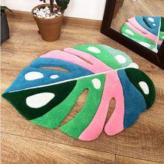 a colorful rug is on the floor in front of a mirror and potted plant