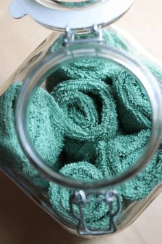 a jar filled with green towels sitting on top of a table