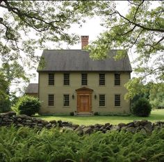 a large house with a brown door surrounded by greenery