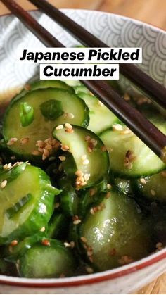 a bowl filled with cucumbers and chopsticks