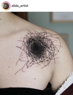 a woman's shoulder with a bird nest tattoo on her upper arm and chest