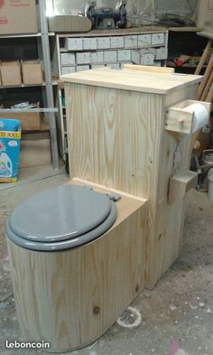 a wooden toilet sitting inside of a room next to other woodworking tools and supplies