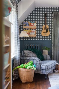 a living room filled with furniture and a guitar hanging on the wall above it's headboard