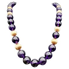 Enhance your fine jewelry collection with this stunning beaded amethyst single strand necklace. Crafted with meticulous attention to detail, this exquisite piece embodies a perfect fusion of sophistication and natural beauty. The incredible necklace features lustrous amethyst beads that showcase a captivating range of purple hues, each unique in its own right. These precious gemstones are carefully selected and meticulously strung together, creating a graceful and alluring single strand. Interspersed among the amethyst beads are fluted gold bead accents that add a touch of elegance and refinement to the design. The intricate fluting detail lends a sense of texture and depth to the necklace, enhancing its overall allure. A single faceted emerald cut amethyst gemstone is set at the clasp, of