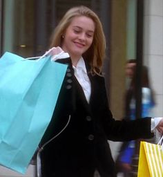 a woman carrying shopping bags and smiling