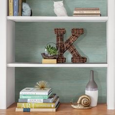 two bookshelves with letters and plants on them