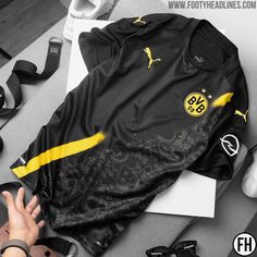 there is a black and yellow shirt with the number 98 on it, next to some shoes