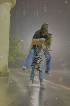 two people standing in the rain with one holding on to another person's back