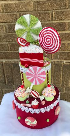 a three tiered cake decorated with candy and lollipops