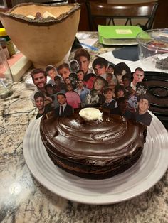 a chocolate cake on a white plate with pictures of people around it