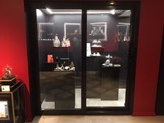 a red room with black glass doors and pictures on the wall behind it in front of an open door