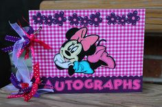 a pink and purple greeting card with a minnie mouse on it, sitting on a wooden table