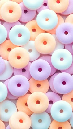 there are many different colored donuts on the table