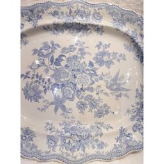 a blue and white platter with floral designs on the bottom, sitting on a table