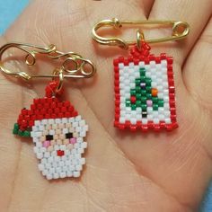 two pieces of bead art are being held in someone's hand, one with a christmas ornament on it