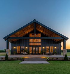 a large house with lots of windows and lights on it's front lawn area