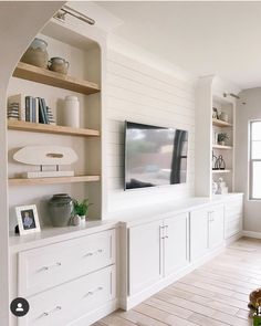 there is a television on the wall in this living room with built - in bookshelves