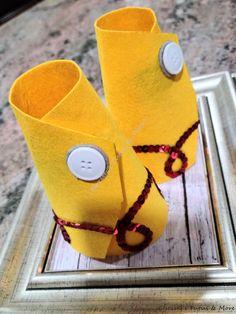 two yellow vases sitting on top of a wooden table