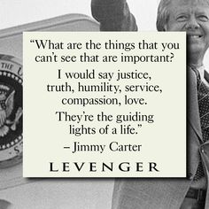 a man in suit and tie standing next to a sign that reads, what are the things that you can't see that are important? i would say justice, truth,