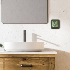 a bathroom with a sink, mirror and clock on the wall next to wooden drawers