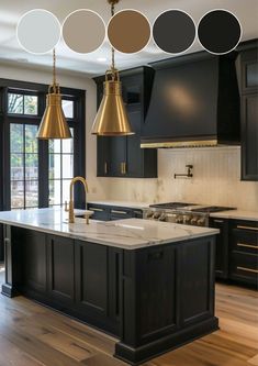 a kitchen with black cabinets and gold pendant lights