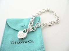 Overview: Offered for sale is a wonderful and gorgeous Return to Tiffany & Co. Sterling Silver Heart Padlock Charm Bracelet. Definitely a Tiffany piece that you will get your money's value for. It works perfectly with pretty much any attire your put on, AND is a great statement piece. The piece looks fabulous worn alone, but is also a wonderful piece with which to start or add to your Tiffany collection. The Heart Padlock charm opens and closes so you can take it off the bracelet and wear it Luxury Lock Jewelry For Gift, Heart-shaped Jewelry Gift With Clasp, Heart-shaped Jewelry With Clasp For Gifts, Return To Tiffany, Heart Padlocks, Gift Pouch, Bracelet Charm, Tiffany Heart, Sterling Silver Heart