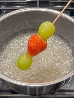 grapes and green olives are being cooked in a pan on the stove with water