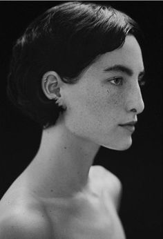 a black and white photo of a woman with her hair up in a bunt