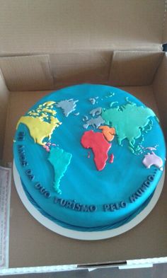 a cake in a box with the world map on it's side and words around the edges