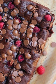 a chocolate cake with raspberries and chocolate chips