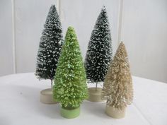 three small christmas trees are sitting on a table