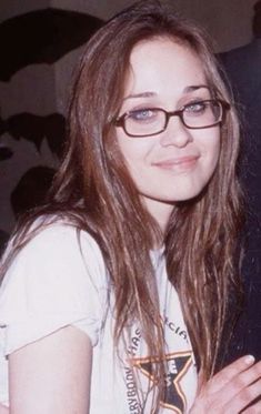 a woman with glasses is smiling for the camera