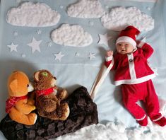 a baby laying on top of a bed next to stuffed animals