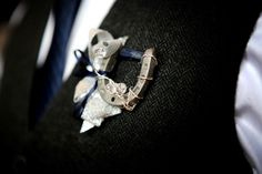 a man wearing a suit and tie with an animal brooch on his lapel