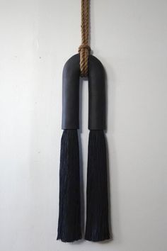 a rope hanging from the side of a wall with two tassels attached to it